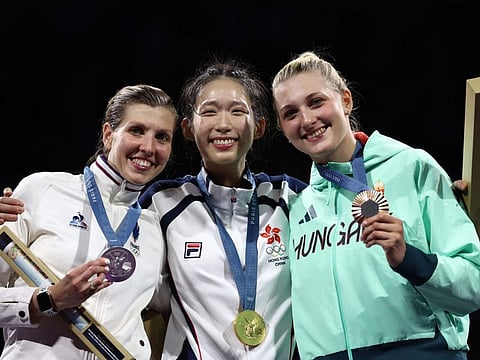 Silver medallist France's Auriane Mallo-Breton (left), gold medallist Hong Kong's Kong Man Wai Vivian and Bronze medalist Hungary's Eszter Muhari celebrate on the podium during the medal ceremony for the women's epee individual competition during the Paris 2024 Olympic Games at the Grand Palais in Paris, on July 27.