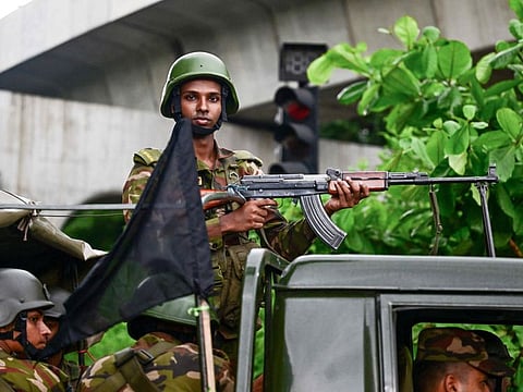Bangladesh army stands guard near a black flag in Dhaka on July 30, 2024, as the nation held a day of mourning for the victims killed in the recent countrywide violence during the anti-quota protests.