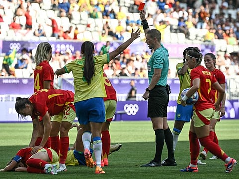 Norwegian referee Espen Eskas (centre) shows a red card to Brazil's forward Marta during the women's group C football match at the Bordeaux Stadium in Bordeaux on Wednesday.