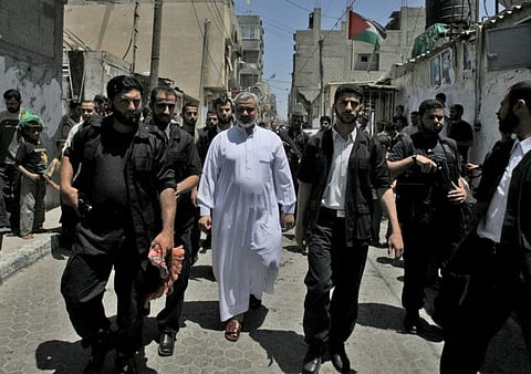 File photo shows Ismail Haniyeh walking through the streets of Gaza City's Al Shati refugee camp after attending the weekly Friday prayers.