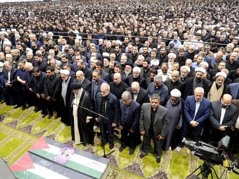 A handout picture provided by the Iranian supreme leader Ayatollah Ali Khamenei office shows him leading the prayer over the coffin of late Hamas leader Ismail Haniyeh and his bodyguard, during his funeral procession in Tehran on August 1, 2024, ahead of his burial in Qatar. q