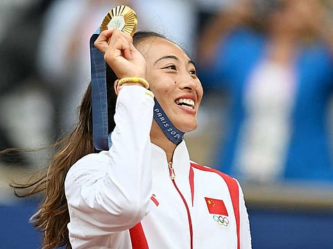 China's Zheng Qinwen poses with her gold medal on the podium at the presentation ceremony for the women's singles tennis event on Court Philippe-Chatrier at the Roland-Garros Stadium during the Paris 2024 Olympic Games, on August 3, 2024.