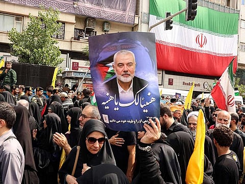Iranians hold portraits of late Hamas leader Ismail Haniyeh during his funeral procession, in Tehran, on August 1, 2024.