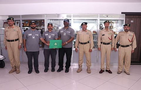 Dubai Police officers standing for photograph after receiving the appreciation certificate for rescuing a European woman from drowning at Marina Beach.