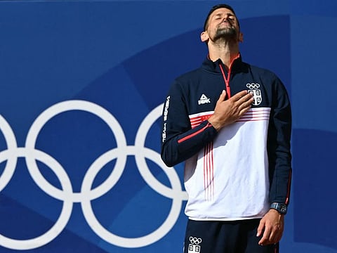 Gold medallist, Serbia's Novak Djokovic poses with his medal on the podium at the presentation ceremony for the men's singles tennis event on Court Philippe-Chatrier at the Roland-Garros Stadium during the Paris 2024 Olympic Games, in Paris Sunday.