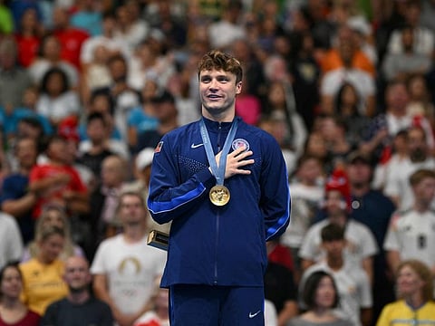 Gold medallist US' Bobby Finke poses the podium of the men's 1500m freestyle swimming event during the Paris 2024 Olympic Games at the Paris La Defense Arena in Nanterre, west of Paris, on Sunday.
