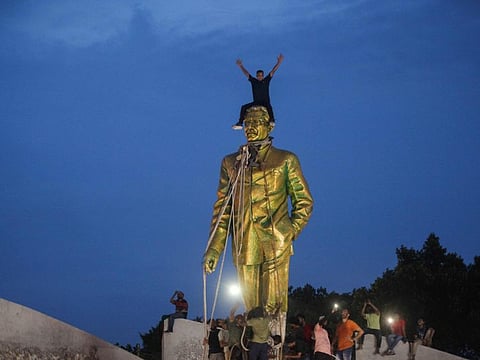 Anti-government protesters climbs atop a statue of Sheikh Mujibur Rahman, Bangladesh's founding father and parent of the country's ousted Prime Minister Sheikh Hasina, in Dhaka on August 5, 2024.