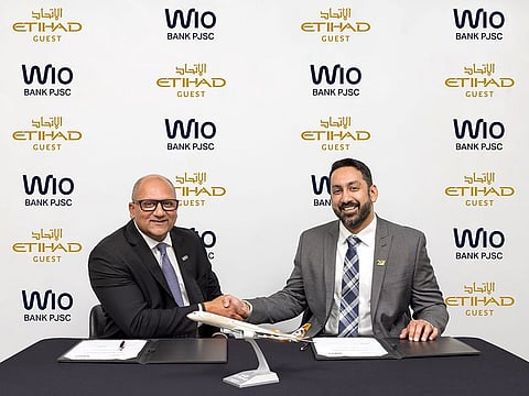 Prateek Vahie, Chief Commercial Officer, Wio Bank (left) and Akhil Anumolu, Senior Vice President E-Commerce, Digital, Marketing and Loyalty at Etihad Airways (right) sign the new partnership agreement at Etihad Airways Headquarters in Abu Dhabi.