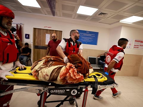 Palestinian medics wheel a body covered in a blanket into a hospital in Jenin, in the occupied West Bank, following an Israeli raid on August 6, 2024.