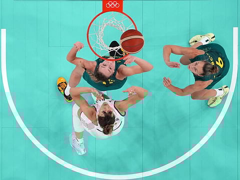 An overview shows (Clockwise from bottom left) Serbia's Tina Krajisnik, Australia's Alanna Smith and Steph Talbot eye a rebound in the women's quarterfinal basketball match during the Paris 2024 Olympic Games at the Bercy Arena in Paris yesterday.