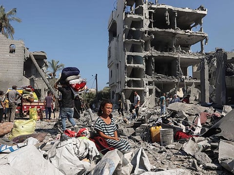 A Palestinian girl sits as people recover belongings in Deir Al balah in the central Gaza Strip, on August 7, 2024, following Israeli bombardment.