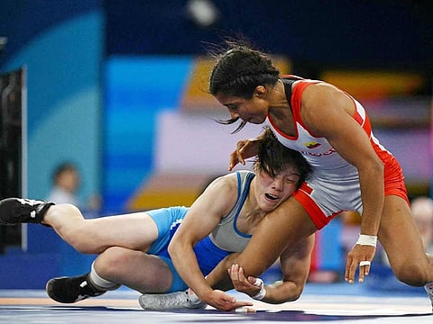 Ecuador's Lucia Yamileth Yepez Guzman (red) wrestles North Korea's Choe Hyo Gyong (blue) in their women's freestyle 53kg wrestling early rounds match at the Champ-de-Mars Arena during the Paris 2024 Olympic Games, in Paris on August 7, 2024.