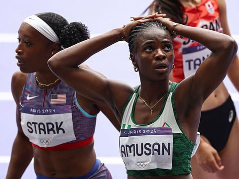 Nigeria's Tobi Amusan reacts next to US' Grace Elizabeth Stark after competing in the women's 100m hurdles semi-finals.