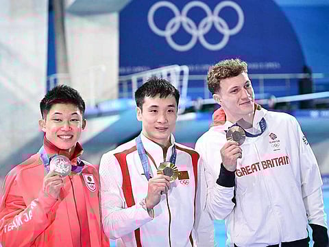 From left: Silver medallist Japan's Rikuto Tamai, gold medallist China's Cao Yuan and bronze medallist Britain's Noah Williams pose during the podium ceremony after the men's 10m platform diving final during the Paris 2024 Olympic Games at the Aquatics Centre in Saint-Denis, north of Paris, on August 10, 2024.