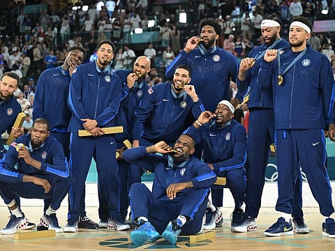 USA team pose on the podium after the men's Gold Medal basketball match against France during the Paris 2024 Olympic Games at the Bercy Arena in Paris on Saturday..