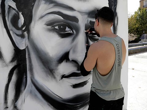 An artist paints a large portrait of Algerian boxer Imane Khelif in Tiaret on August 9, 2024.