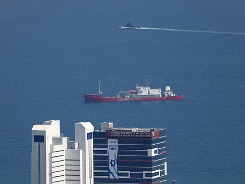 An Israeli submarine (back) is pictured passing behind a ship in the Mediterranean sea off the coast of the northern Israeli city of Haifa on August 12, 2024, as regional tensions rise amid the ongoing war between Israel and the Palestinian Hamas movement in the Gaza Strip.
