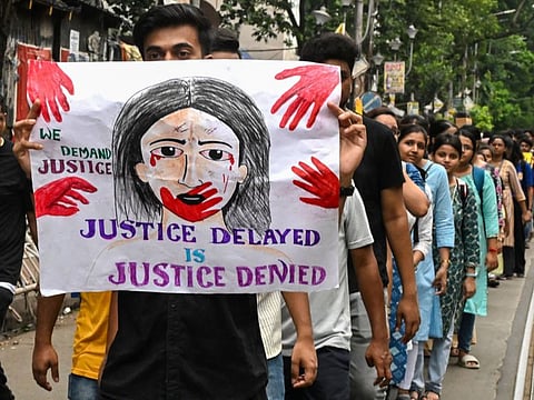 Activists and medical professionals hold a poster during a protest to condemn the rape and murder of a young medic in Kolkata on August 12, 2024.