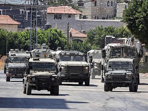 Israeli armoured vehicles drive on a road during a raid in Tubas city in the occupied West Bank on August 14, 2024.