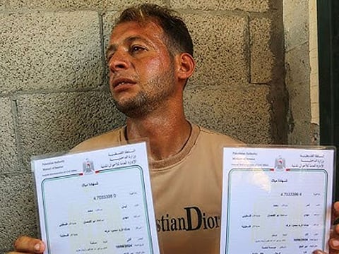 Abu Al Qumsan holds the birth certificates in Khan Yunis in Gaza on August 14.