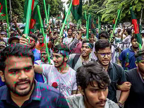 Protesters hold Bangladesh's national flags as they march to block the house of Sheikh Mujibur Rahman, ‘Bangabandhu’ the first president of independent Bangladesh and father of ousted ex-premier Sheikh Hasina, in Dhaka on August 15, 2024, to mark the anniversary of his assassination.
