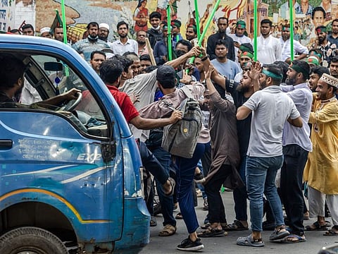 Protesters surround a suspected sympathiser of ousted ex-premier Sheikh Hasina, near the house of her father Sheikh Mujibur Rahman, Bangabandhu the first president of independent Bangladesh, in Dhaka on August 15, 2024.
