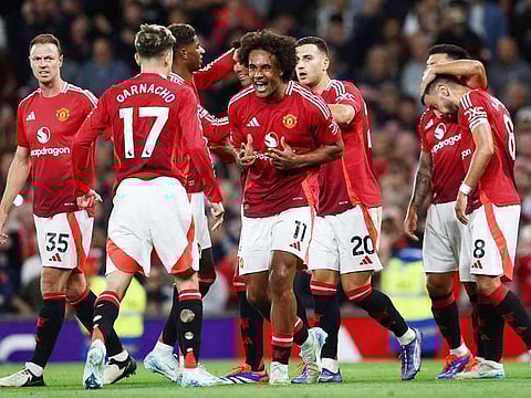 Manchester United's striker Joshua Zirkzee (C) celebrates with teammates after scoring the opening goal of the English Premier League football match against Fulham at Old Trafford in Manchester, north west England, on August 16, 2024.