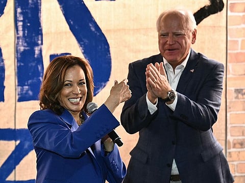 US Vice-President and Democratic presidential candidate Kamala Harris (L) speaks as her running mate Minnesota Governor Tim Walz looks on during a stop on their campaign bus tour in Rochester, Pennsylvania, on August 18, 2024.