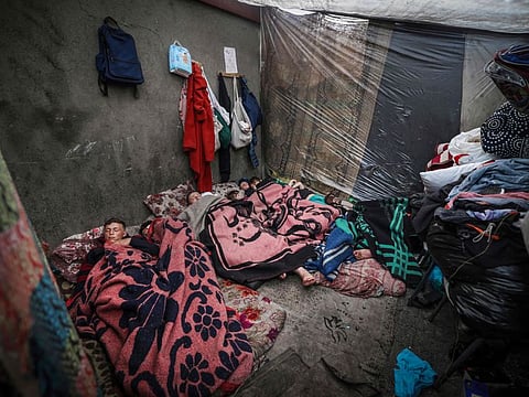 Displaced Palestinians sleep in a tent at a camp beside a street in Rafah, southern Gaza Strip.