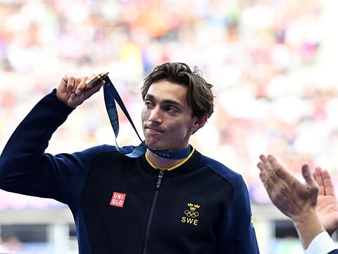 Gold medallist Sweden's Armand Duplantis celebrates on the podium after competing in the men's pole vault final of the athletics event during the Paris 2024 Olympic Games at Stade de France in Saint-Denis, north of Paris, on August 6.