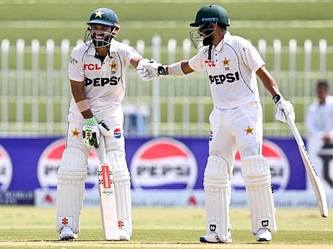 Pakistan's Mohammad Rizwan (left) celebrates with Saud Shakeel share a laugh during the second day of the first Test cricket match against Bangladesh at the Rawalpindi Cricket Stadium in Rawalpindi on Thursday.