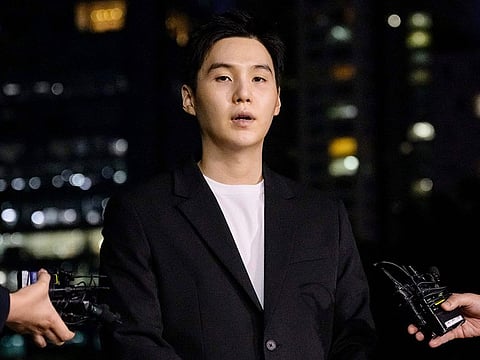 South Korean singer SUGA, of the K-pop mega group BTS, arrives at a police station in the Yongsan district of Seoul on August 23, 2024, for questioning after being charged with riding an electric scooter under the influence of alcohol late at night on August 6.