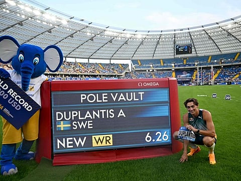 First placed Swedens Armand Duplantis poses next to a board displaying his new 6,26 meters world record after the men's pole vault event of the Silesia Diamond League athletics meeting in Chorzow, Poland, on Sunday.