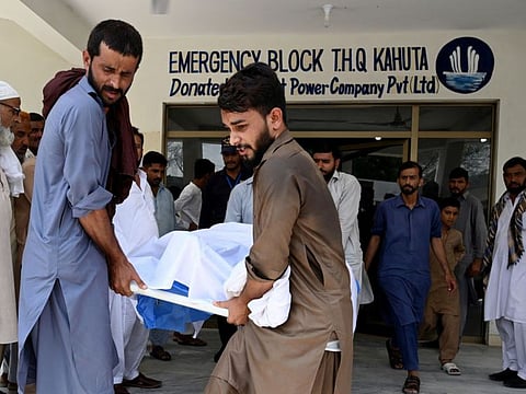 People move the body of a bus accident victim from a hospial in Kahuta, Punjab province, on August 25, 2024.