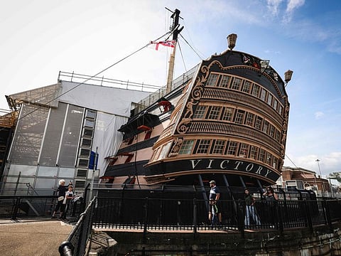 Visitors walk around the stern of HMS Victory, Britain's most celebrated naval warship as it undergoes a restoration project, "Victory Live: The Big Repair" at Portsmouth Historic Dockyard on the south coast of England on August 21, 2024.