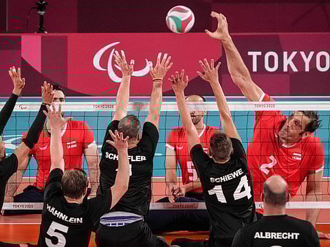 Iran's Morteza Mehrzad Selakjani (right) hits the ball during the preliminary round pool B sitting volleyball match against Germany at Makuhari Messe Hall during the Tokyo 2020 Paralympic Games in Chiba on August 28, 2021.