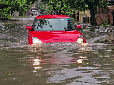 A vehicle wades through the severe waterlogged Maninagar area following heavy rainfall, in Ahmedabad.