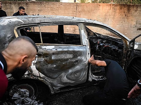 People check a burnt car in the small town of Zababdeh, southeast of Jenin in the occupied West Bank on August 30, 2024, following an Israeli army raid.
