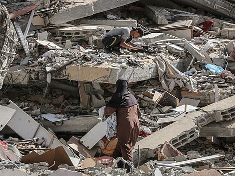 Palestinians search amongst the rubble of a levelled building after the Israeli army withdrew from some blocks in the city of Deir Al Balah, central Gaza, on Thursday, Aug. 29, 2024.