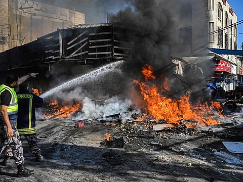 Palestinian Civil Defence firefighters douse the flames during a fire in a fruit market in the occupied West Bank city of Jenin amid ongoing Israeli raids on August 31, 2024.