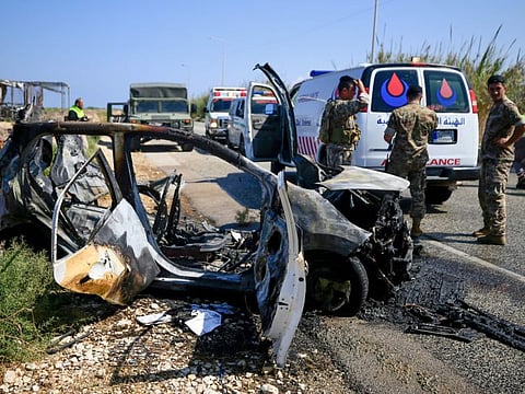 Lebanese security forces and rescue teams inspect a charred car that was hit by an Israeli drone strike on the road leading to the southern Lebanese coastal town of Naqura on the border with Israel on September 2, 2024.
