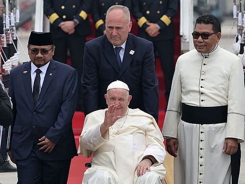 Pope Francis (C, in wheelchair) is welcomed during his arrival at Soekarno–Hatta International Airport in Jakarta on September 3, 2024.