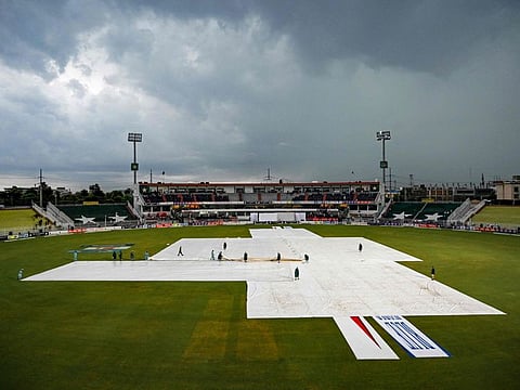 Groundmen cover the pitch owing to dark clouds as poor light halts play during the fourth day of the second and last Test cricket match between Pakistan and Bangladesh, at the Rawalpindi Cricket Stadium in Rawalpindi on September 2.