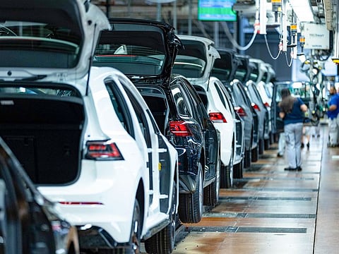Workers fit car doors to VW Golfs on the assembly line at the Volkswagen AG factory in Wolfsburg, Germany. Some 680,000 people are employed by Volkswagen worldwide, with over 300,000 working for the group in Germany.