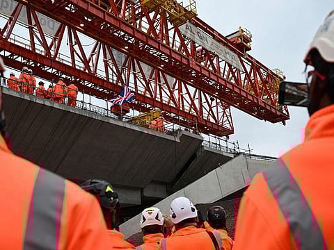 A Union Jack flag flaps in the air as workers fixe the final deck segment of HS2s 2.1-mile on the viaduct crossing the Colne Valley, in Maple Cross, north-west of London, on September 5, 2024.
