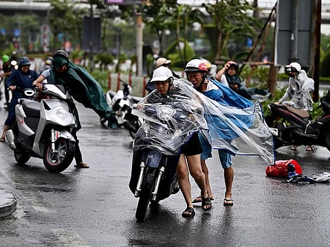 Motorcyclists struggle from the strong wind of Typhoon Yagi in Hai Phong city on September 7, 2024.