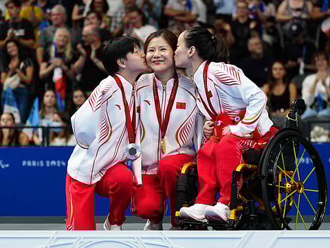 (From left) Silver medallist China's He Shenggao, Gold medallist China's Lu Dong and Bronze medallist China's Liu Yu celebrate during the victory ceremony for the women's S5 50m backstroke final event at the Paris 2024 Paralympic Games at The Paris La Defense Arena in Nanterre, west of Paris, on September 3.