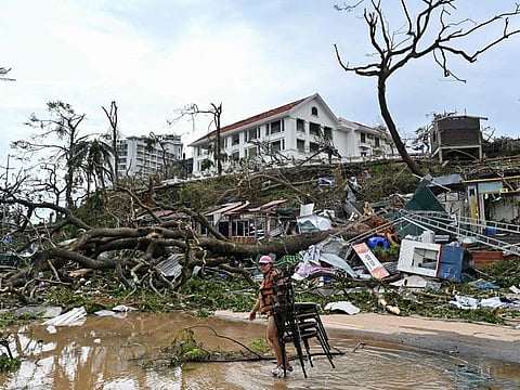 A woman collects chairs amid debris and fallen trees after Super Typhoon Yagi hit Ha Long, in Quang Ninh province, on September 8, 2024.