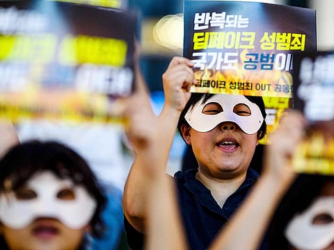 Activists wearing eye masks, hold posters reading ‘Repeated deepfake sex crimes, the state is an accomplice too’ during a protest against deepfake porn in Seoul on August 30, 2024.