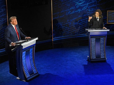 US Vice President and Democratic presidential candidate Kamala Harris speaks as former US President and Republican presidential candidate Donald Trump listens during a presidential debate at the National Constitution Center in Philadelphia, Pennsylvania, on September 10, 2024.